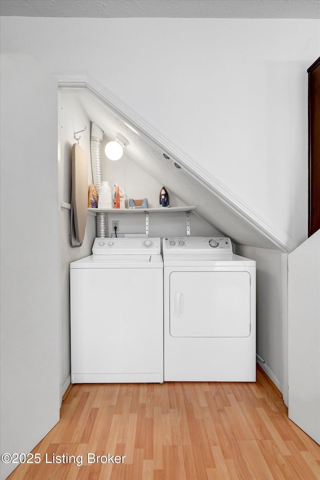 washroom featuring light wood finished floors, laundry area, and independent washer and dryer