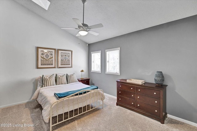 bedroom with baseboards, lofted ceiling with skylight, and carpet flooring