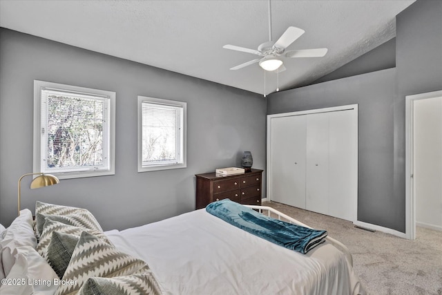 bedroom featuring a closet, carpet flooring, ceiling fan, and vaulted ceiling