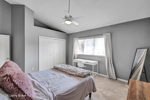 bedroom with a ceiling fan, baseboards, vaulted ceiling, a closet, and light carpet