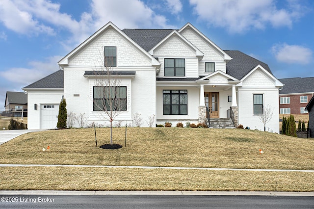 view of front of home with an attached garage, concrete driveway, a front yard, and roof with shingles