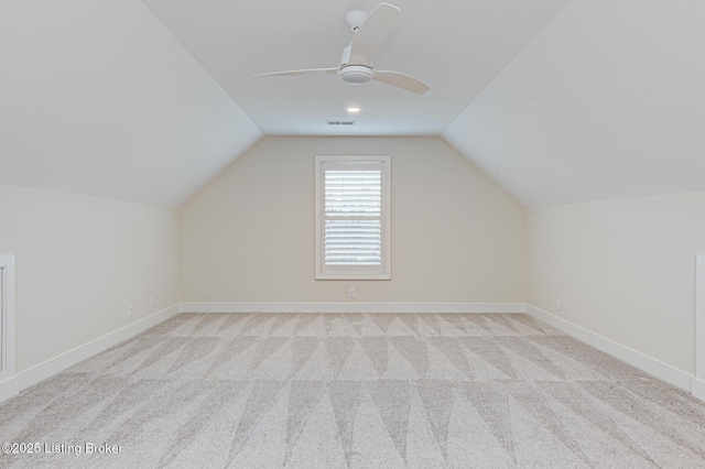 additional living space featuring lofted ceiling, light colored carpet, and baseboards