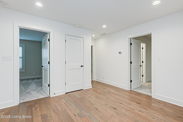 spare room featuring baseboards, recessed lighting, visible vents, and light wood-type flooring