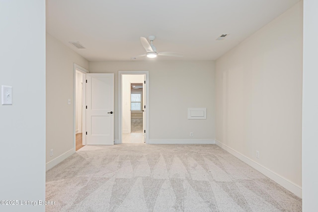 spare room with carpet flooring, baseboards, visible vents, and a ceiling fan