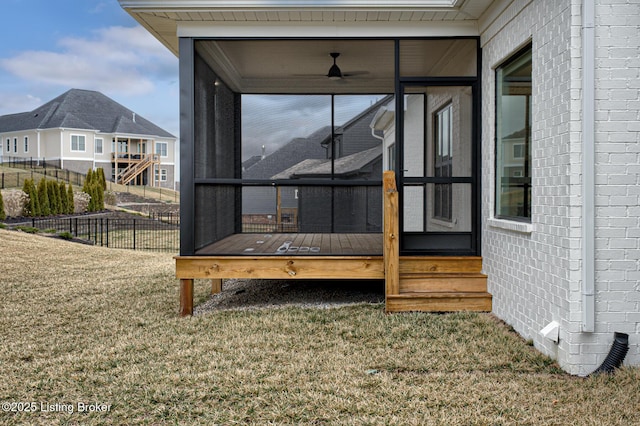 exterior space with fence, a sunroom, and a wooden deck