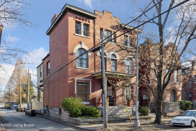 exterior space featuring fence and brick siding