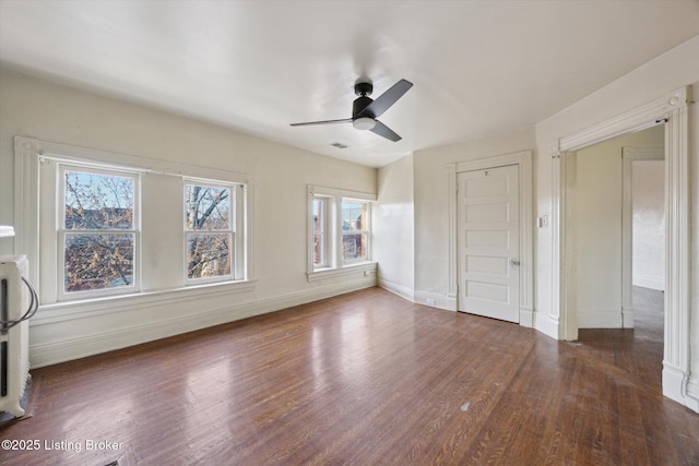 interior space featuring a ceiling fan, visible vents, wood finished floors, and baseboards