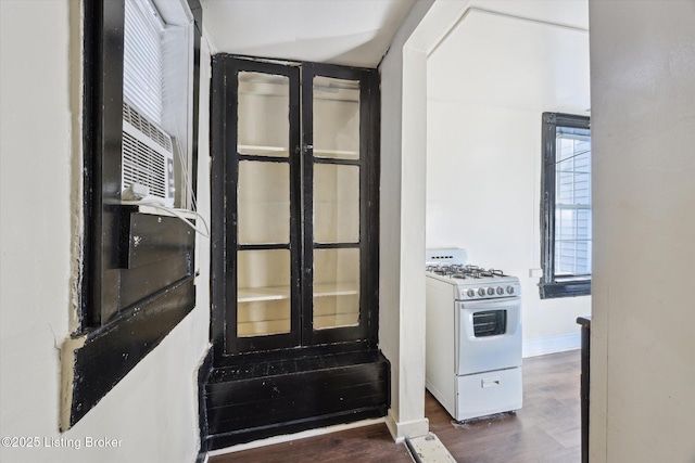 interior space featuring white gas stove, baseboards, and wood finished floors