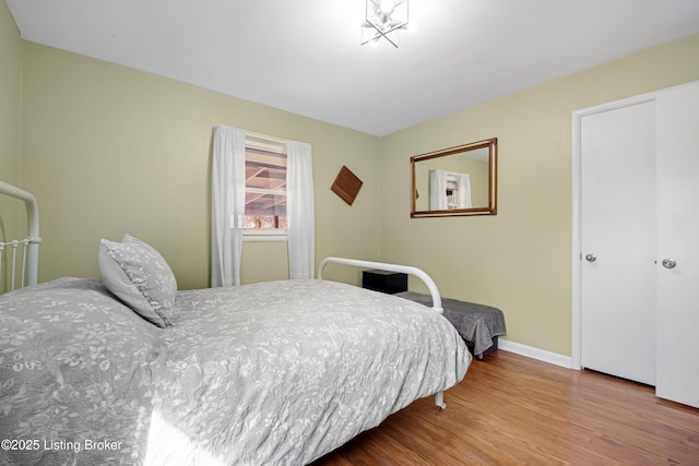 bedroom featuring wood finished floors and baseboards