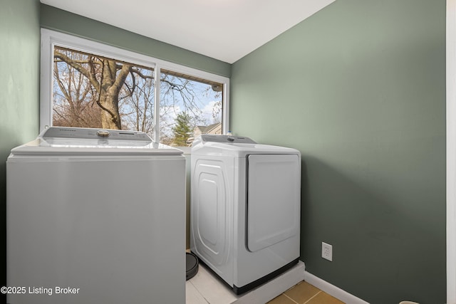 laundry room featuring light tile patterned floors, laundry area, washing machine and dryer, and baseboards