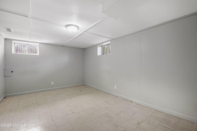 below grade area with tile patterned floors, visible vents, and baseboards