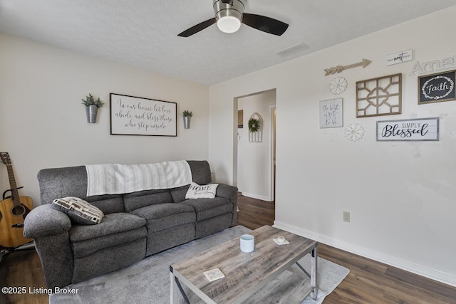 living area featuring ceiling fan, baseboards, and wood finished floors