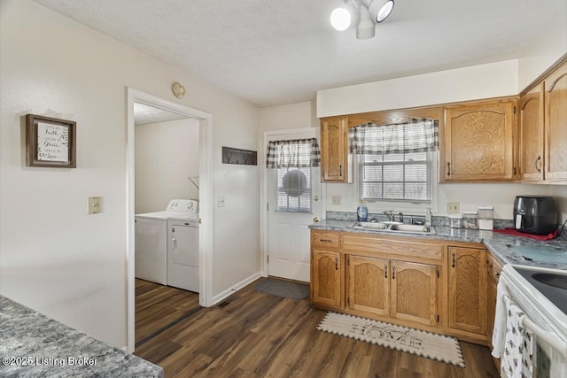 kitchen featuring independent washer and dryer, dark wood-type flooring, electric stove, and a sink