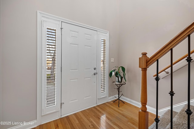 entryway featuring stairway, plenty of natural light, baseboards, and light wood-style flooring