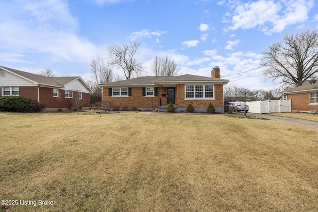 ranch-style house with brick siding, a chimney, a front yard, and fence