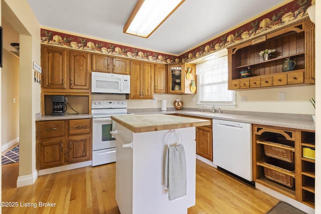 kitchen featuring white appliances, light wood-style flooring, light countertops, and open shelves