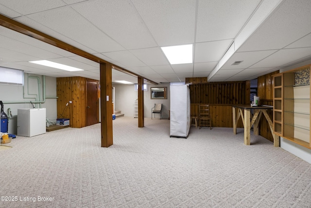 basement with carpet flooring, washer / dryer, visible vents, and wooden walls