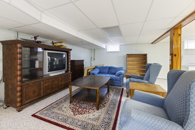 carpeted living area with a paneled ceiling