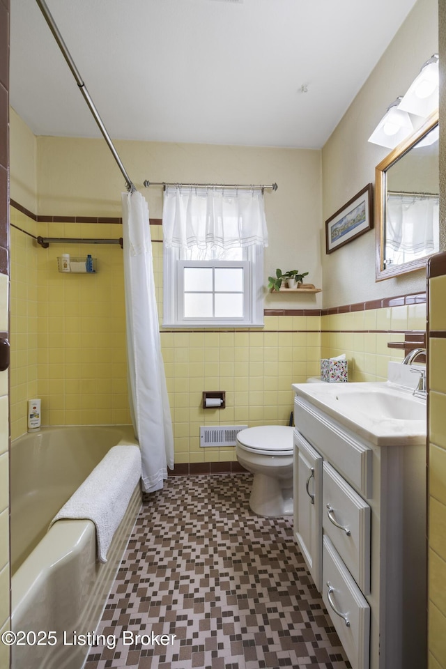 bathroom with vanity, shower / bathtub combination with curtain, visible vents, tile walls, and toilet