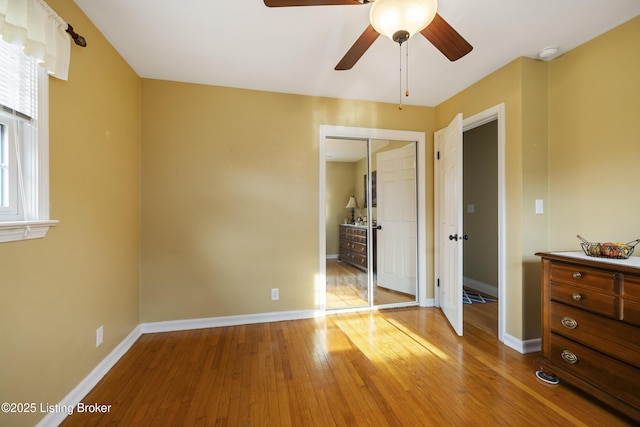 bedroom featuring ceiling fan, baseboards, and light wood-style floors