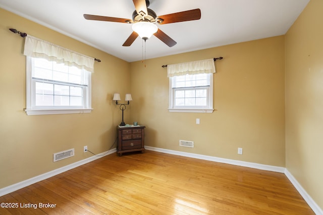 empty room featuring visible vents, baseboards, and light wood-style flooring