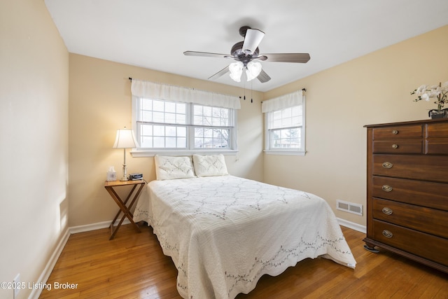 bedroom with a ceiling fan, baseboards, visible vents, and light wood-type flooring