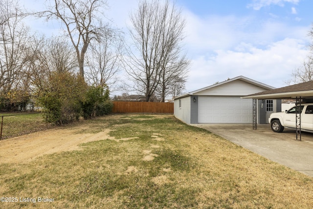 view of yard with a detached garage, an outdoor structure, and fence