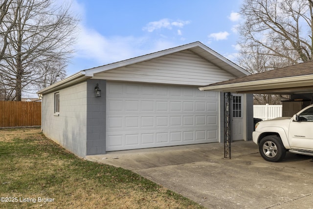 detached garage with a carport and fence