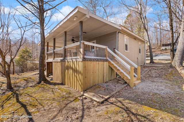 view of side of home featuring stairs and a ceiling fan