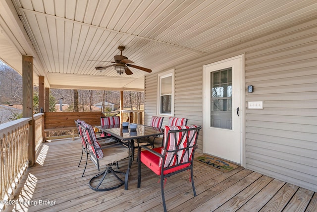 wooden deck featuring outdoor dining area and a ceiling fan