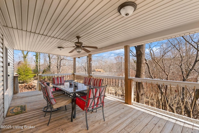 wooden deck featuring outdoor dining area and a ceiling fan