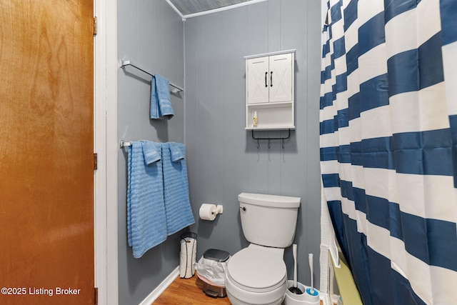 full bath with curtained shower, toilet, wood finished floors, and baseboards