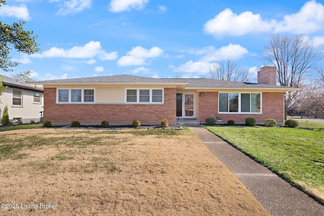 single story home with a front yard, brick siding, and a chimney