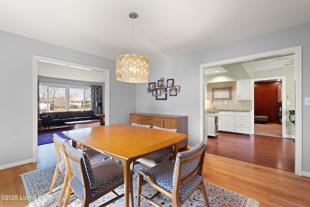 dining room featuring baseboards and light wood finished floors