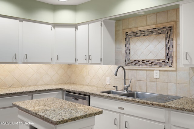 kitchen featuring tasteful backsplash, white cabinets, and dishwasher