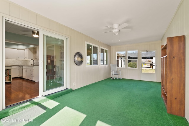 unfurnished sunroom with a ceiling fan and a sink