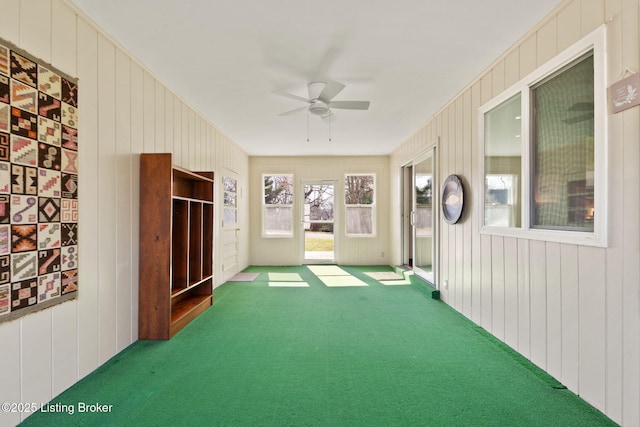 unfurnished sunroom featuring ceiling fan