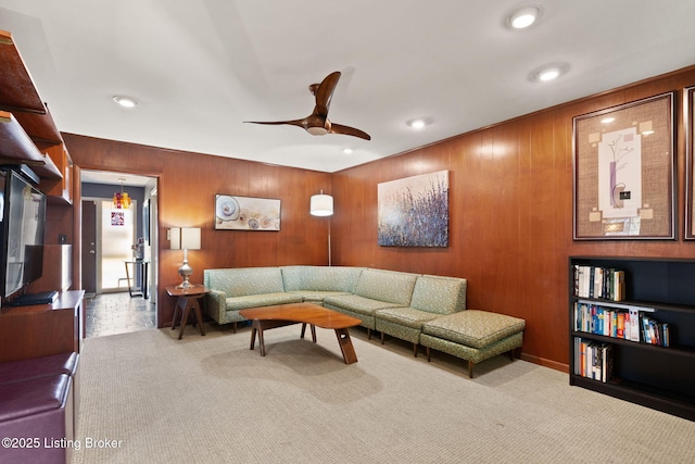 living room featuring recessed lighting, carpet floors, wood walls, and a ceiling fan