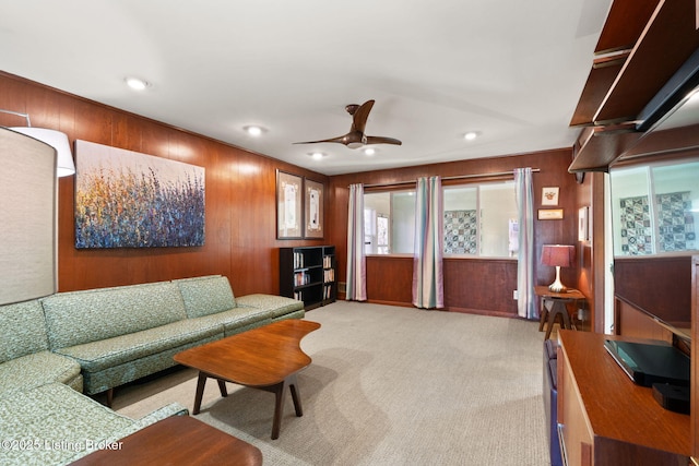 living room with ceiling fan, wooden walls, recessed lighting, and light carpet