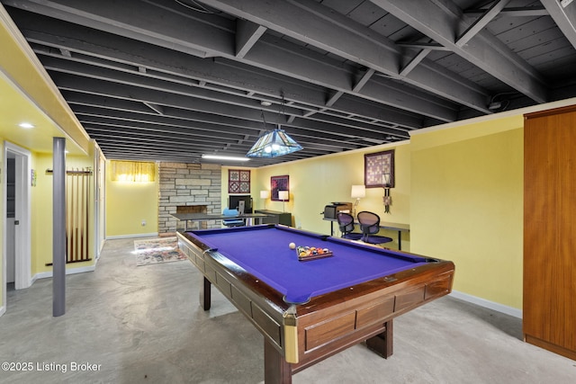 rec room with a stone fireplace, pool table, concrete floors, and baseboards