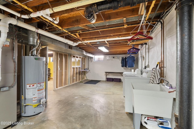 below grade area featuring a sink, independent washer and dryer, and water heater