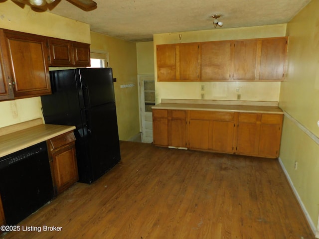 kitchen with black appliances, wood finished floors, and light countertops