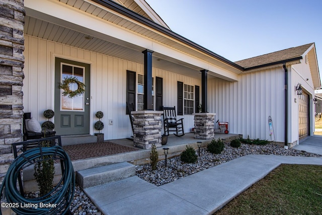 doorway to property with board and batten siding, covered porch, and an attached garage