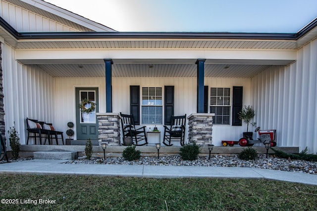 doorway to property with board and batten siding and covered porch