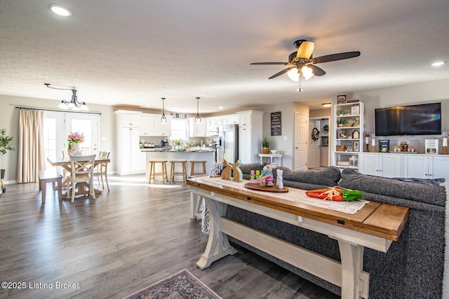 living room featuring baseboards, recessed lighting, wood finished floors, a textured ceiling, and a ceiling fan