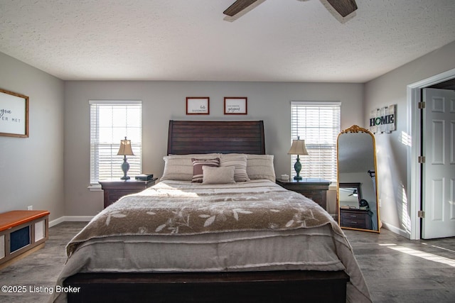 bedroom featuring wood finished floors, baseboards, and a textured ceiling