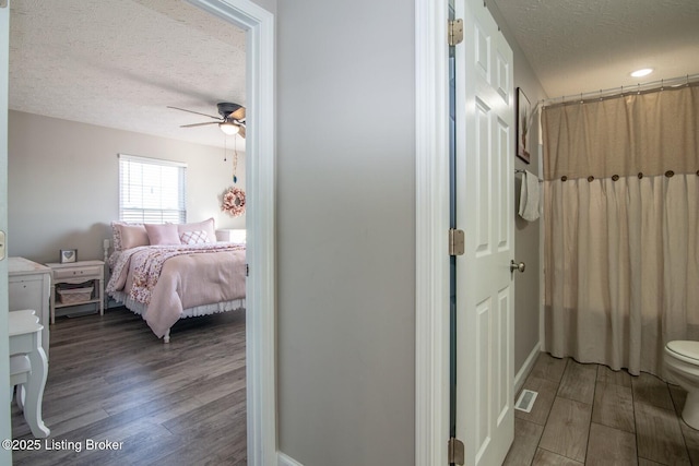 bathroom featuring wood finished floors, visible vents, ensuite bathroom, and a textured ceiling