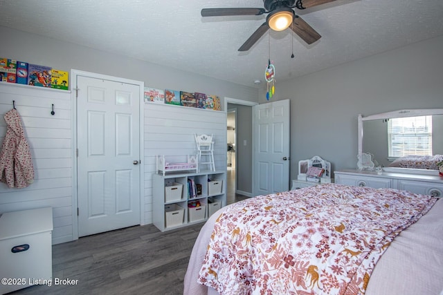 bedroom featuring a textured ceiling, ceiling fan, and dark wood-style flooring