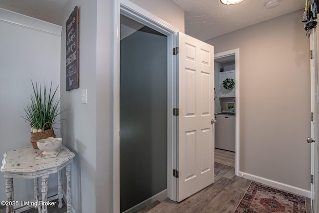 hallway with washer / clothes dryer, wood finished floors, and baseboards