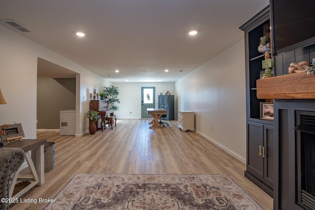 home office with a fireplace, recessed lighting, visible vents, and light wood finished floors